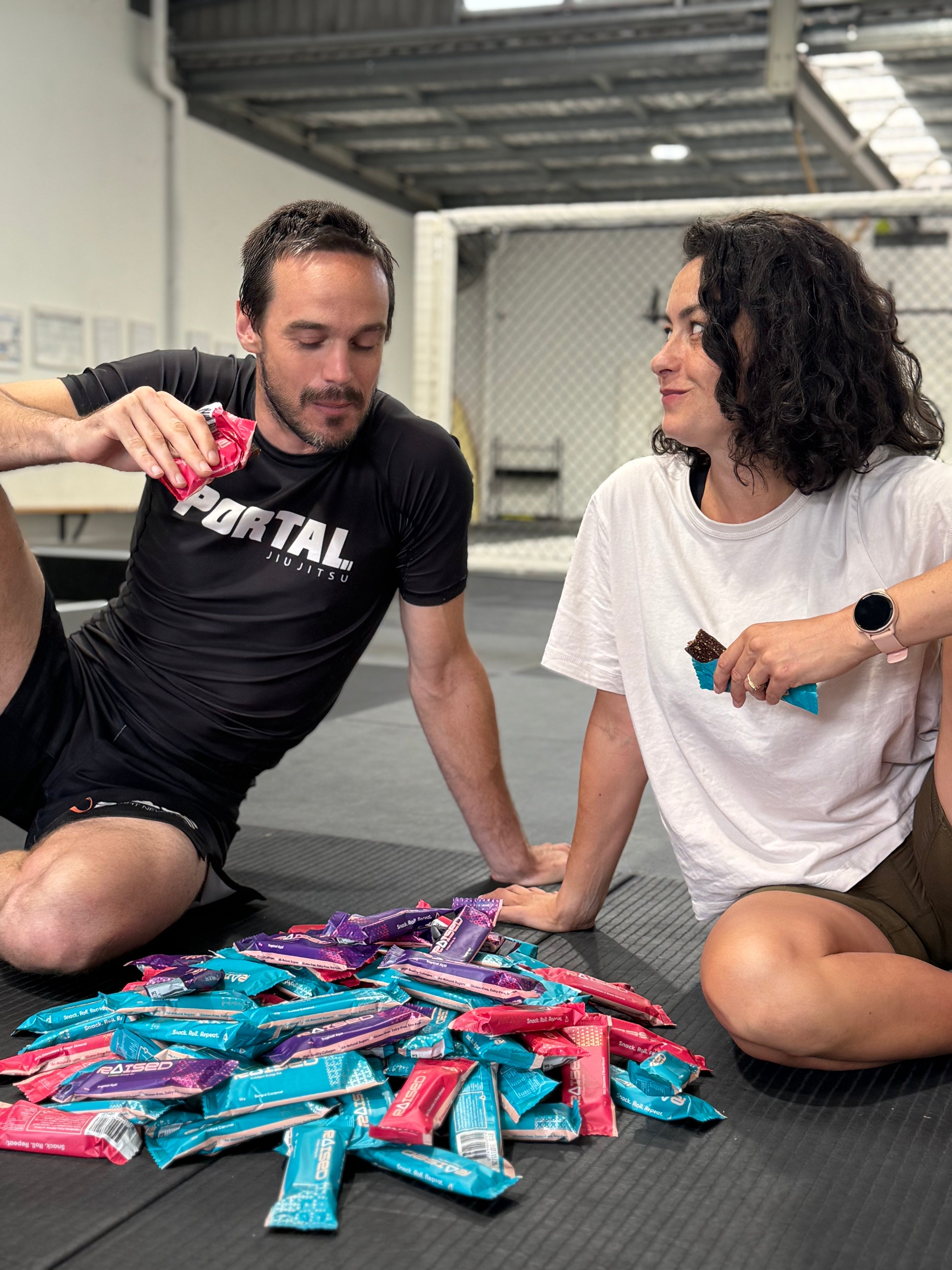 Two individuals enjoying snacks while discussing collagen benefits for skin on a gym floor.