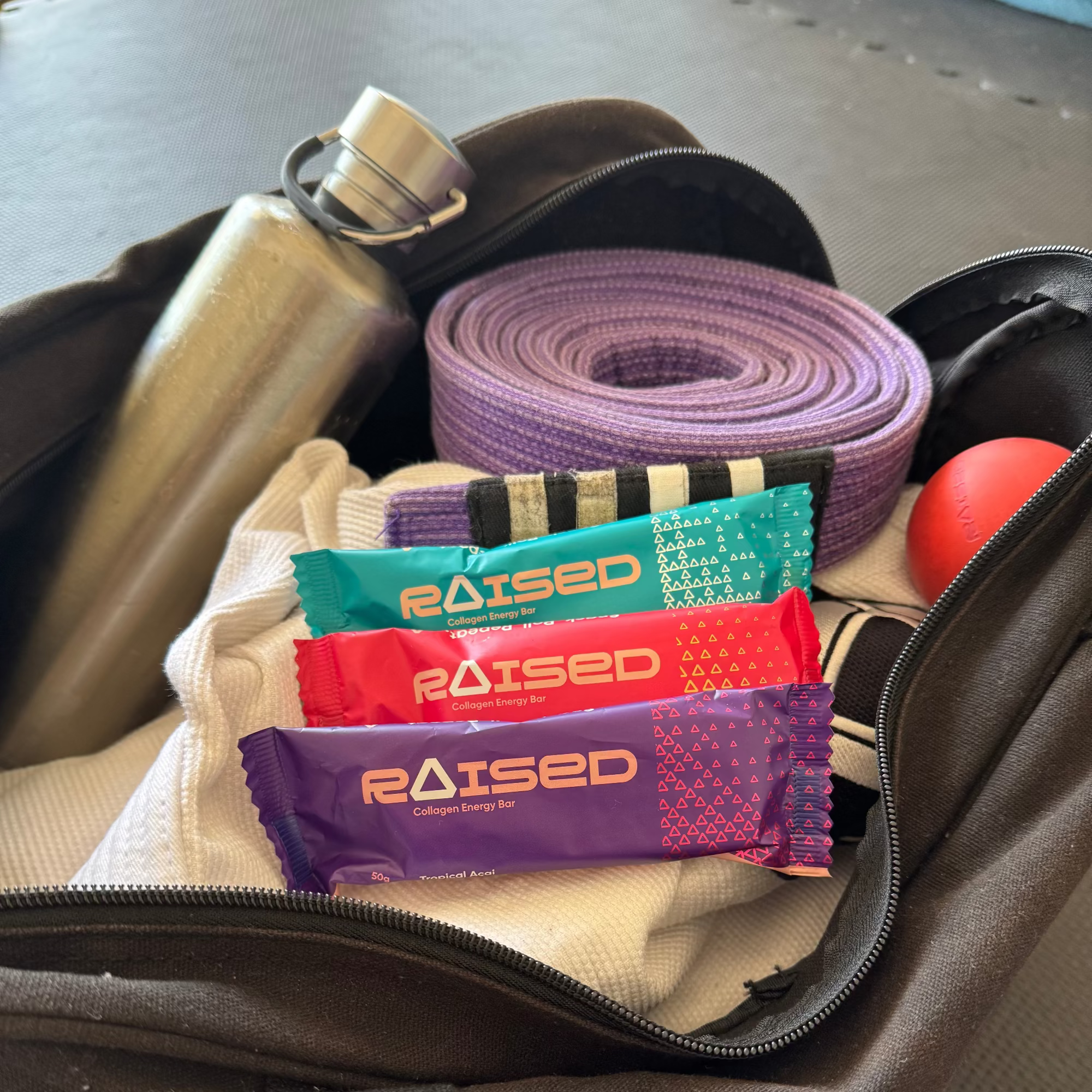 Assorted energy bars with 'Raised' branding in a bag